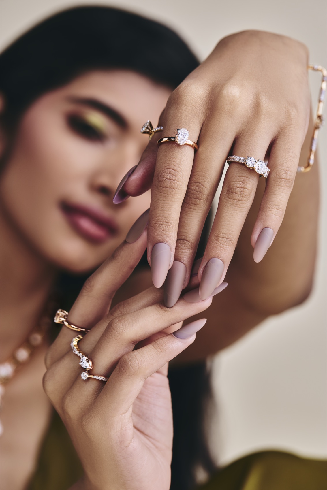 Hands wearing KAHA diamond rings, framing the face