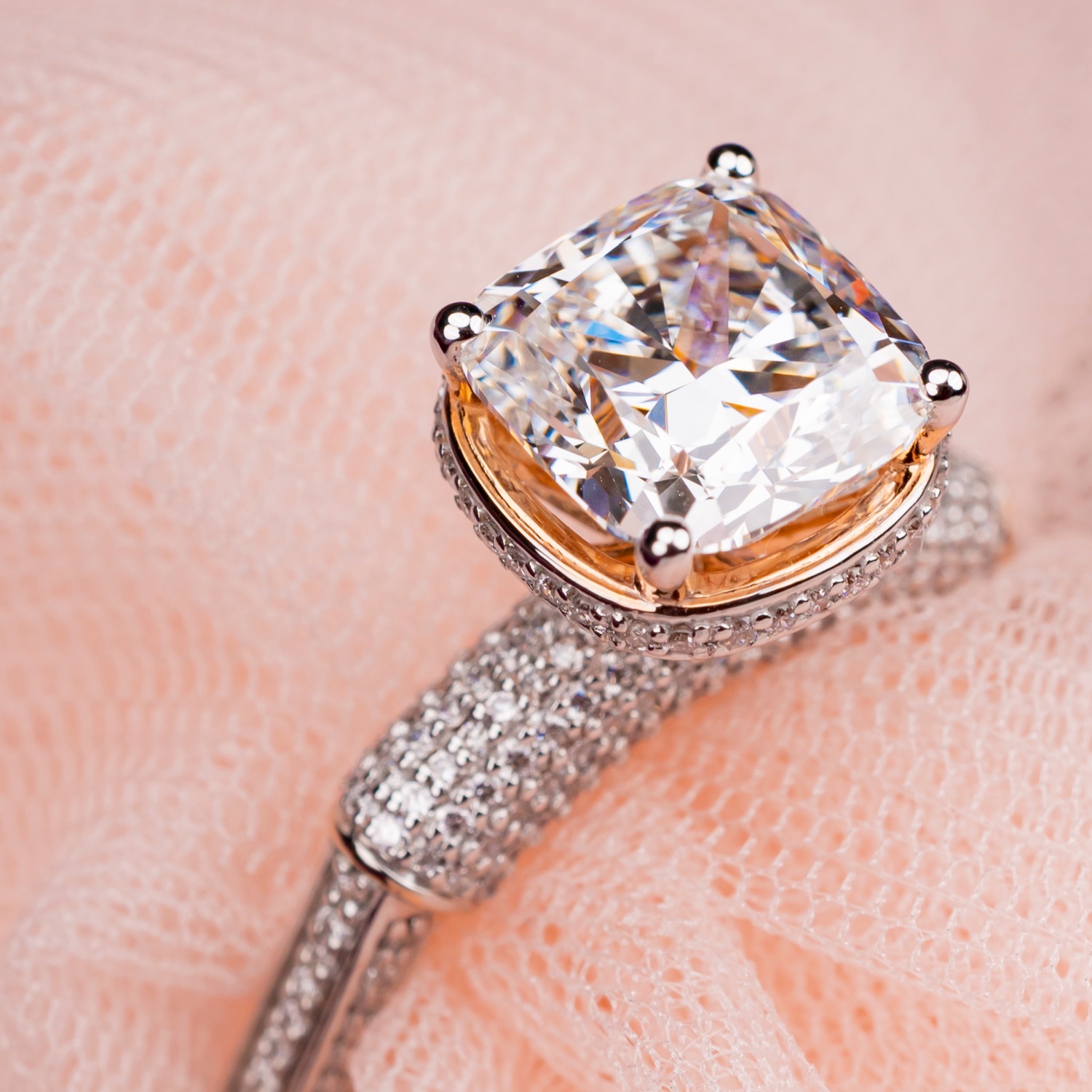 A cushion-cut KAHA diamond ring resting on blush tulle